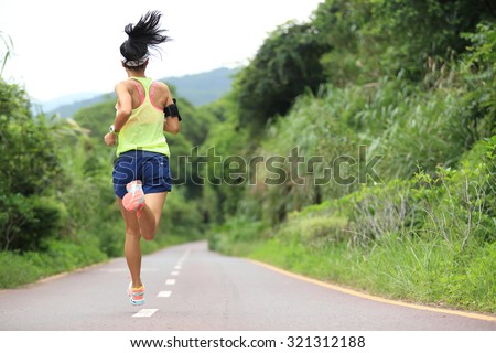 trail runner athlete running on forest trail. woman fitness jogging workout wellness concept.