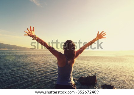 young cheering woman jogger open arms at sunrise seaside,vintage effect