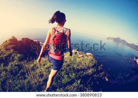 young fitness woman trail runner on sunrise seaside trail