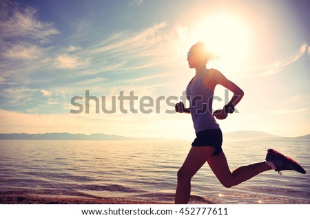 healthy lifestyle young woman runner running on sunrise seaside