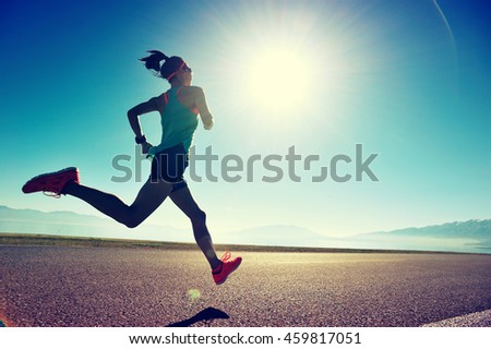 young fitness woman runner running on sunrise seaside trail