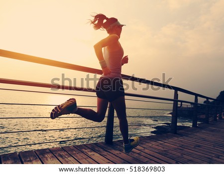 healthy lifestyle young fitness sports woman  trail runner running on seaside