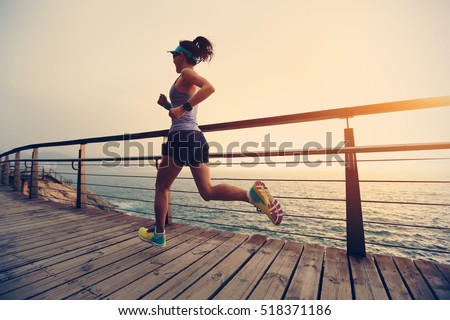healthy lifestyle young fitness sports woman  trail runner running on seaside