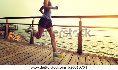 young fitness sports woman  trail runner running on seaside