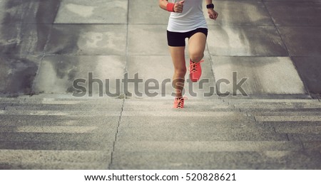 young sport woman running upstairs on city stairs