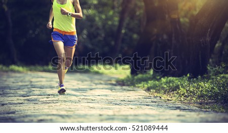 young fitness woman trail runner running on forest