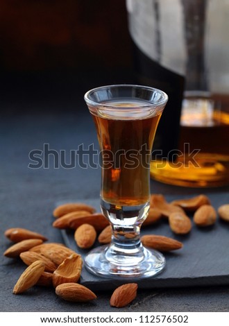 Almond liquor amaretto with whole nuts on a dark background