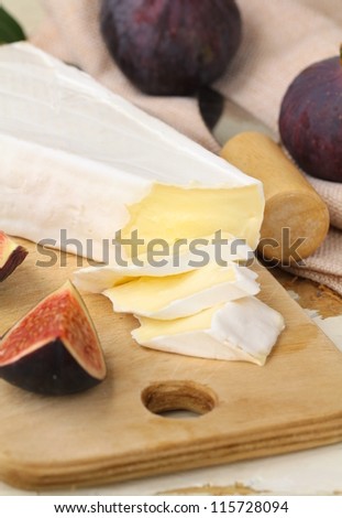 Brie cheese and  fruit  figs on a wooden board