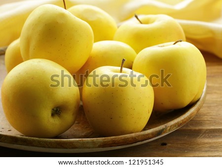 fresh autumn yellow apples on wooden table