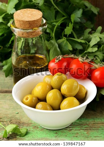 still life of green  marinated olives,  herbs, cherry tomatoes