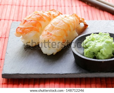 portion of sushi with shrimp on a stone plate