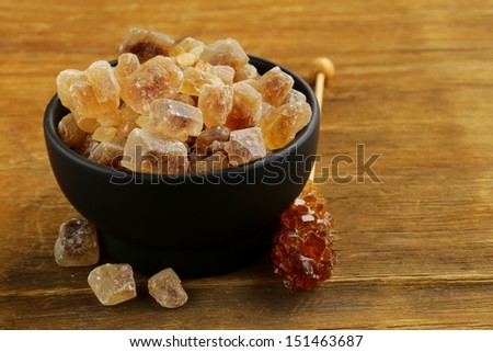 Rock candy sugar in a cup on wooden table