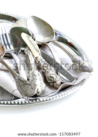 vintage cutlery with old-fashioned napkin on a silver tray