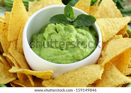 cup with guacamole and corn chips -  traditional Mexican appetizer