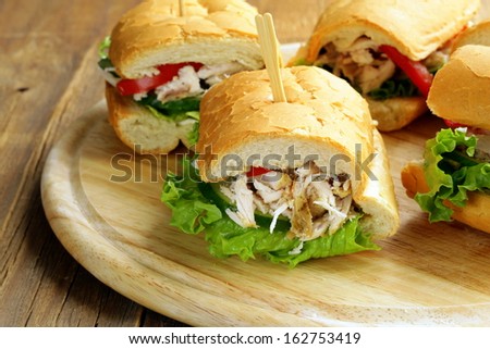 panini sandwich with chicken and vegetables on a wooden board