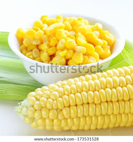 Canned corn in a bowl and fresh cobs