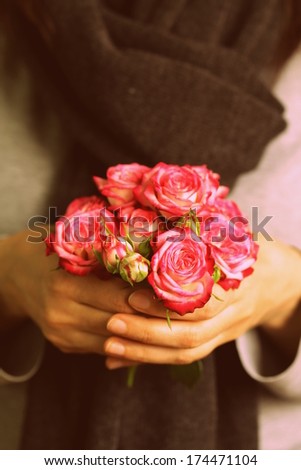 bouquet of pink roses in female hands (toning in retro style)