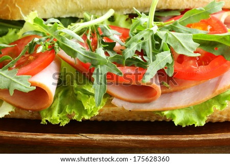 baguette sandwich with arugula, ham and tomatoes