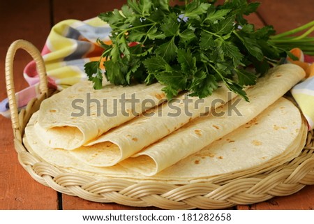 stack of homemade whole wheat flour tortillas on a wooden table