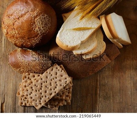 assortment of bread (rye, whole wheat, for toast) on wooden background
