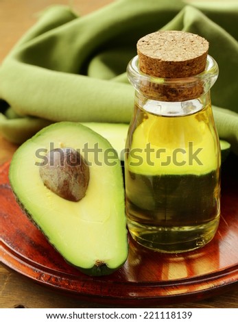 oil of avocado and fresh fruit on wooden table