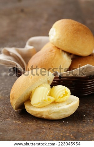 yellow dairy butter on a fresh bun bread for breakfast
