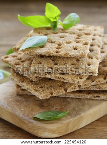 Dry flat bread crisps with herbs on a wooden board
