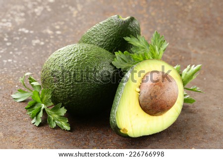 fresh organic ripe avocado with leaves of parsley