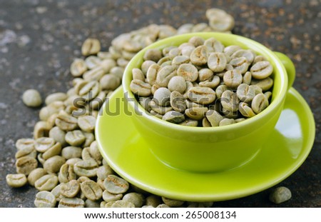 green coffee beans in a green cup close-up, healthy food