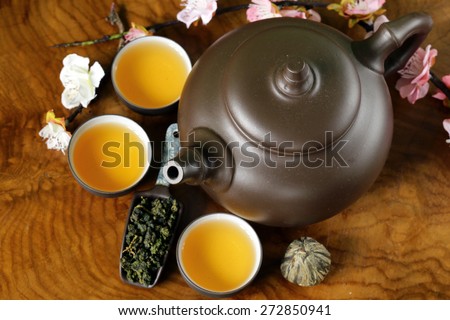 tea set (teapot, cups and different green tea) on a wooden background