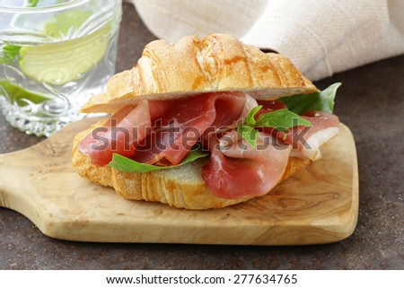 gourmet sandwich croissant with ham and  basil
