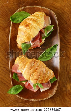gourmet sandwich croissant  with ham and basil