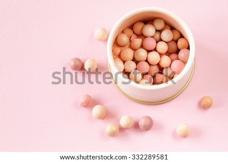 cosmetics rouge balls in the bank on a pink background