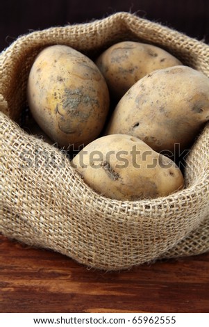 Bag of organic potatoes on a wooden background
