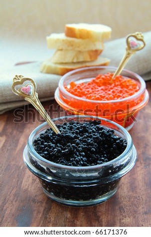 red and black caviar in glass jars with gold spoons