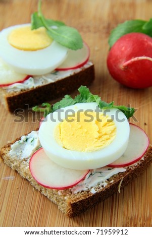 sandwiches with eggs radishes and  cottage cheese  on the  board