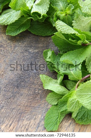 bunch of fresh green mint on wooden cutting board