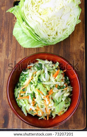 Coleslaw salad in  bowl on a brown background