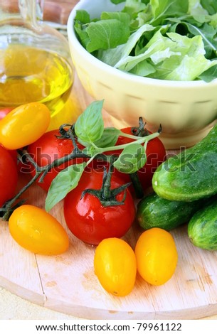 ingredients for the salad, cucumbers, tomatoes, olive oil and green salad mix