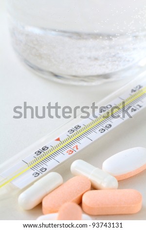 Electronic thermometer, pills  and glass with water