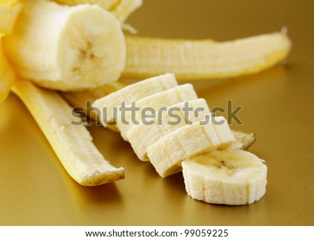 ripe banana cut into slices on a gold background