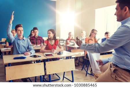 education, school and people concept - group of happy students and teacher with papers or tests