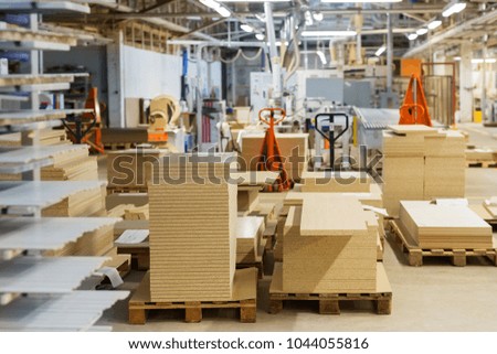 production, manufacture and woodworking industry concept - chipboards storing at furniture factory