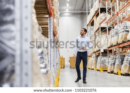 wholesale, logistic business, export and people concept - happy businessman with tablet pc computer checking goods at warehouse