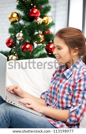 picture of happy woman with laptop computer and christmas tree.
