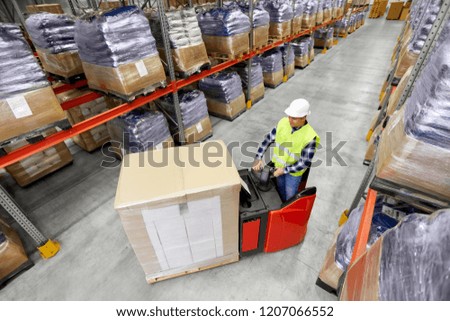 logistic business, shipment and people concept - loader operating forklift and loading boxes at warehouse