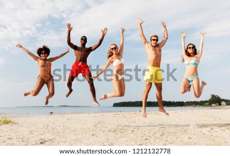 friendship, summer holidays and people concept - group of happy friends jumping and having fun on beach