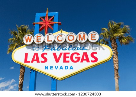 landmarks concept - welcome to fabulous las vegas sign and palm trees over blue sky in united states of america
