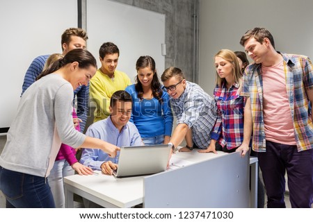 education, high school, technology and people concept - group of students and teacher with laptop computer in classroom