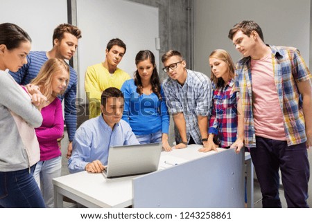 education, high school, technology and people concept - group of students and teacher with laptop computer in classroom
